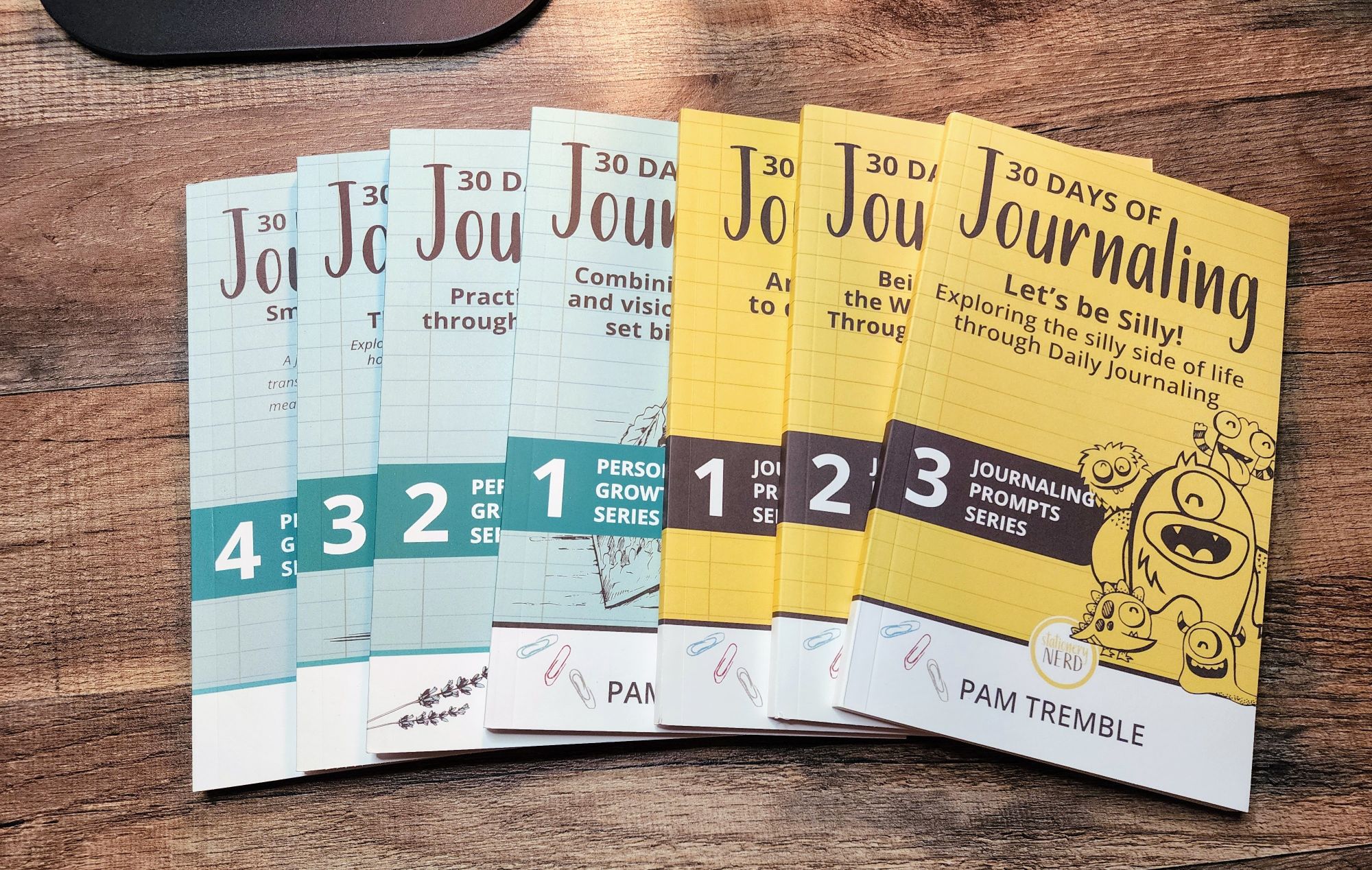 a series of prompted journaling books laying on a table